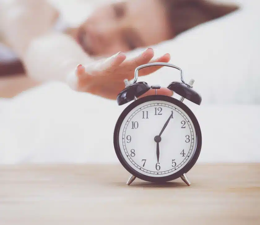 Alarma y reloj con persona dormida
