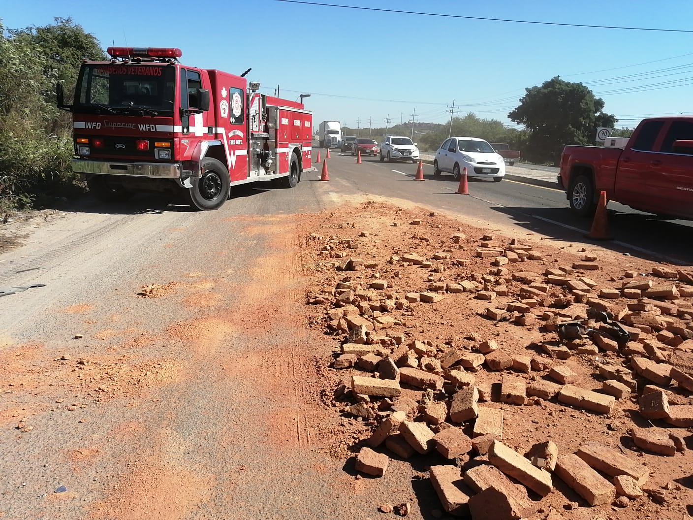 Choque en carretera internacional entre una camioneta y un camión de ladrillos.