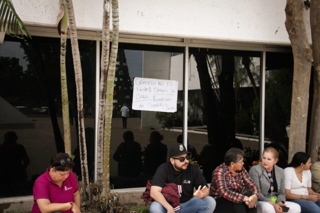 cartel en pared de vidrio y trabajadores de la Sepyc sentados