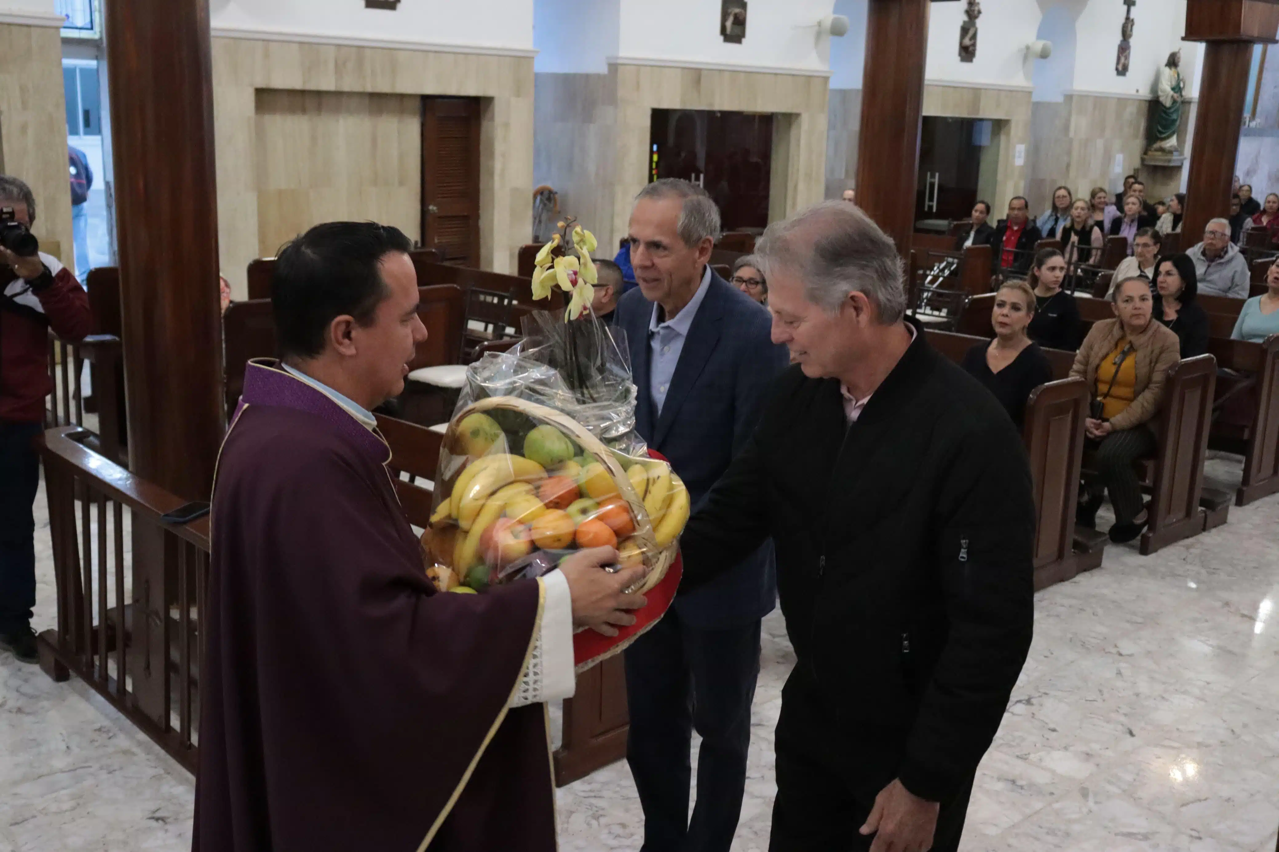 Alcalde de Ahome y funcionario entegando ofrenda a sacerdote