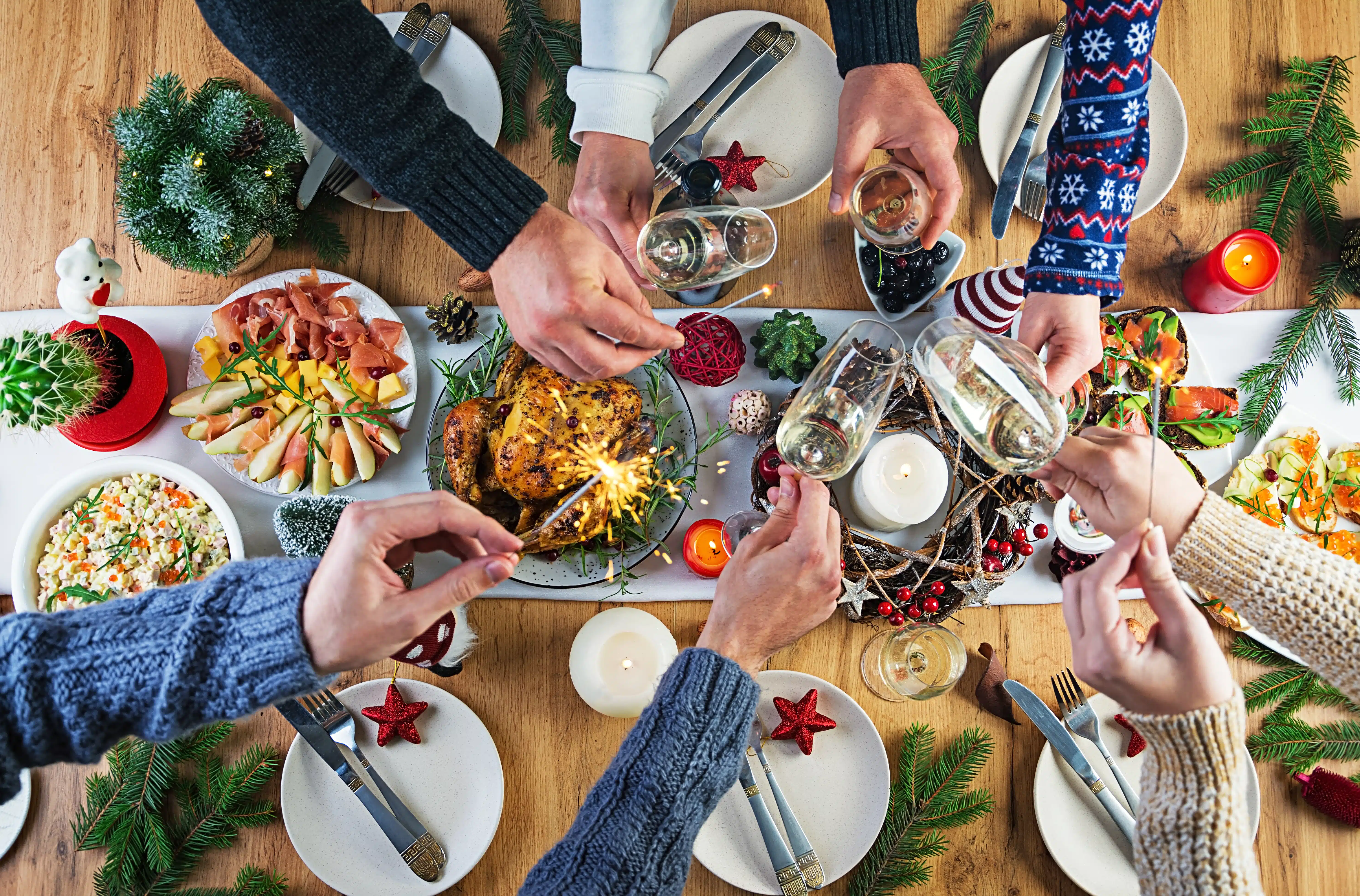 Personas brindan sobre la mesa de la cena de Año Nuevo