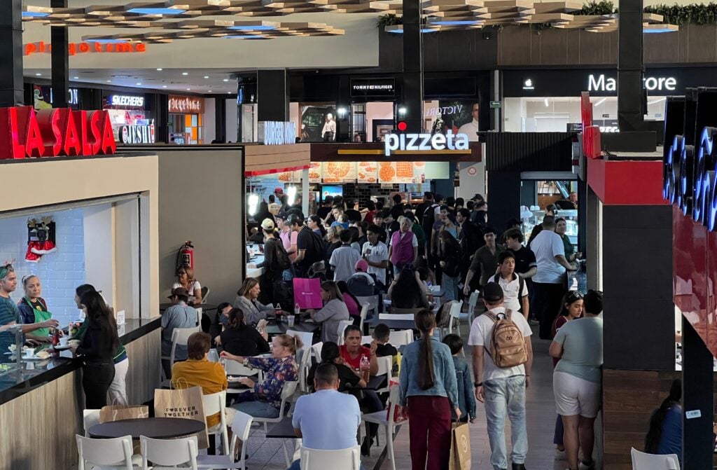 Multitud de personas realizan compras en plaza comercial