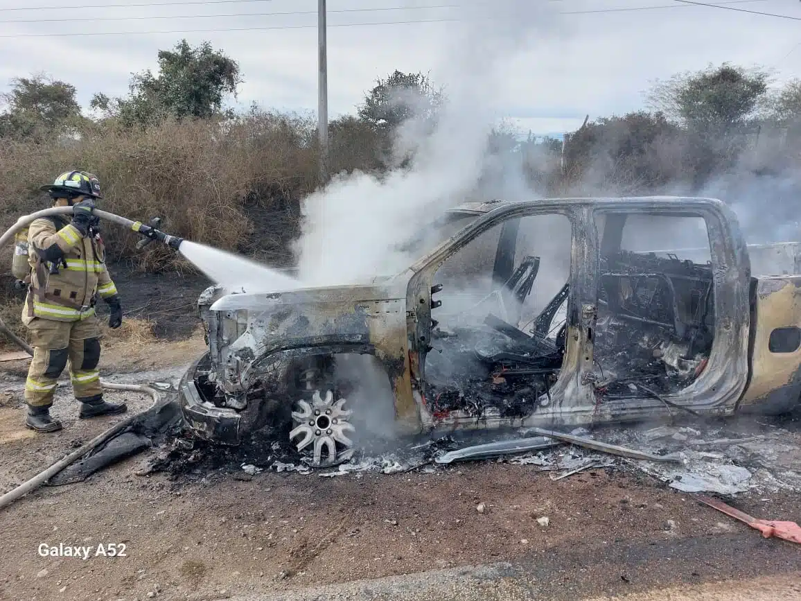 Bomberos atendiendo el incendio de la camioneta