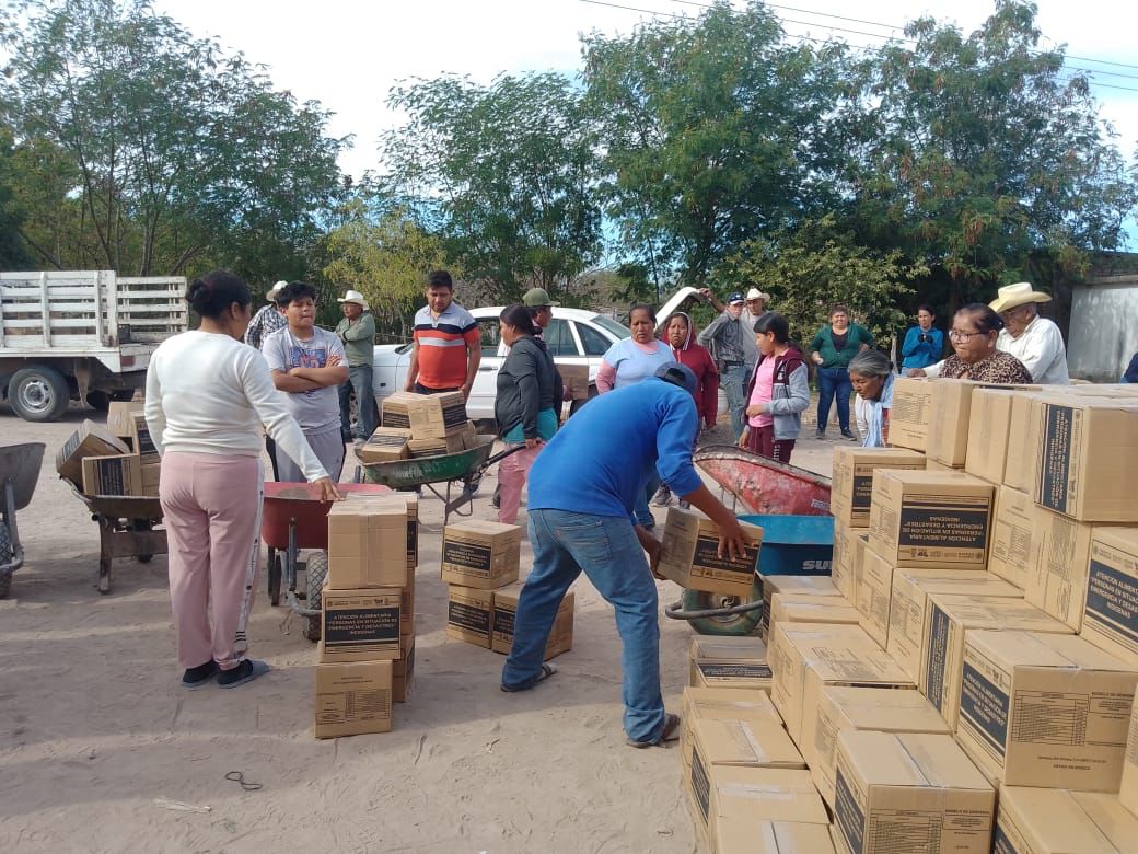 Familias de comunidades vulnerables recibiendo cajas con apoyo alimentario