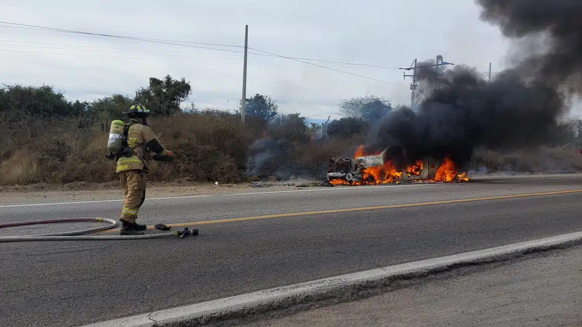 Bombero preparándose para combatir el fuego en una camioneta por la carretera libre Mazatlán-Culiacán