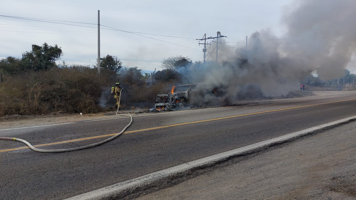 Bomberos atendiendo el incendio de la camioneta