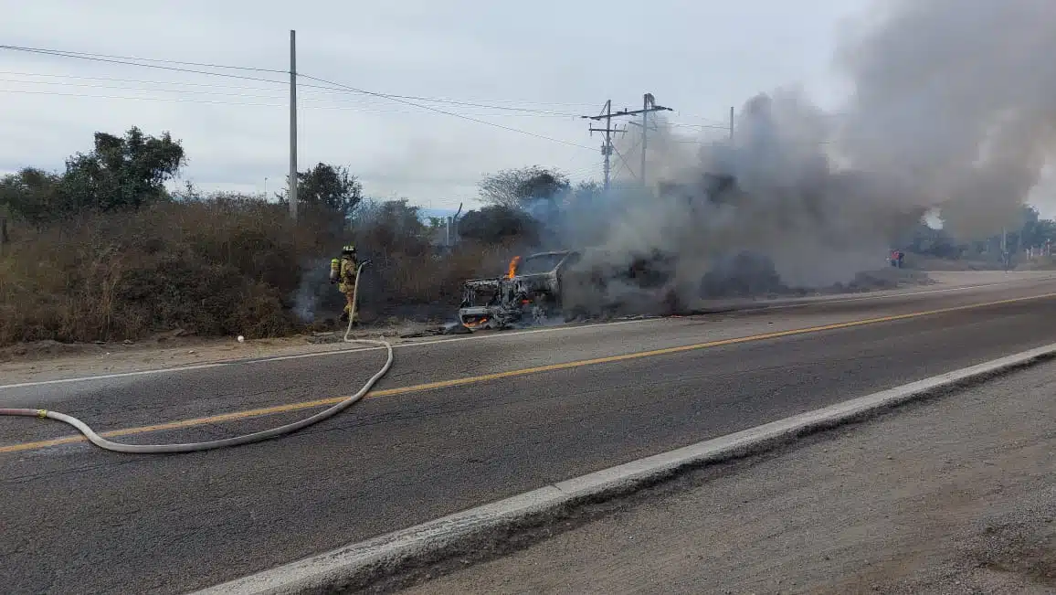 Bomberos atendiendo el incendio de la camioneta