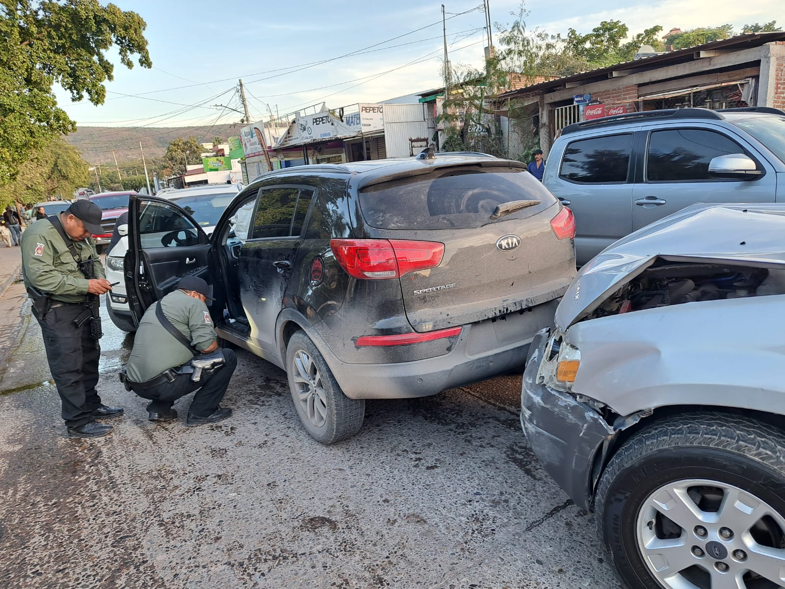 Autoridades y testigos observan el resultado del choque múltiple donde quedó abandonada una camioneta Kia en la que viajaban hombres armados