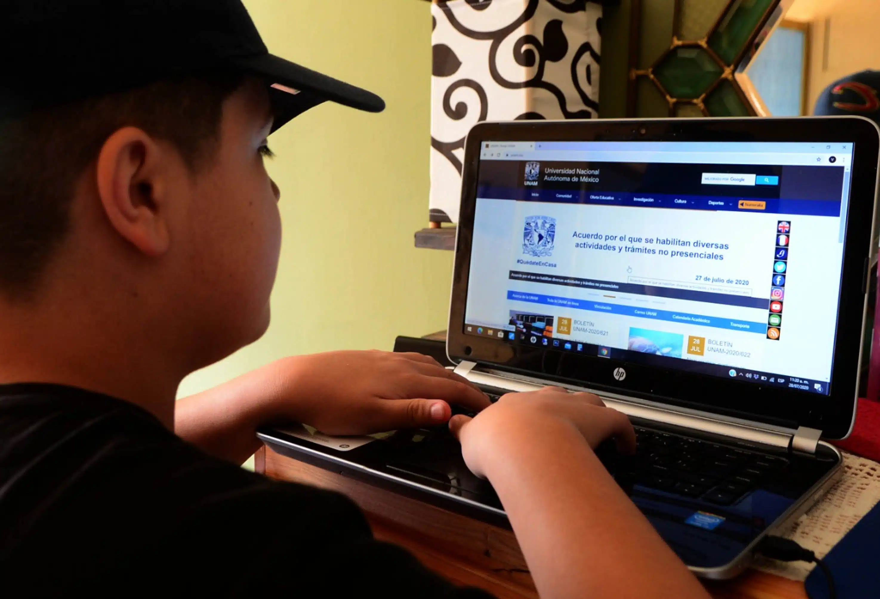 Joven frente a la computadora en clases en linea.