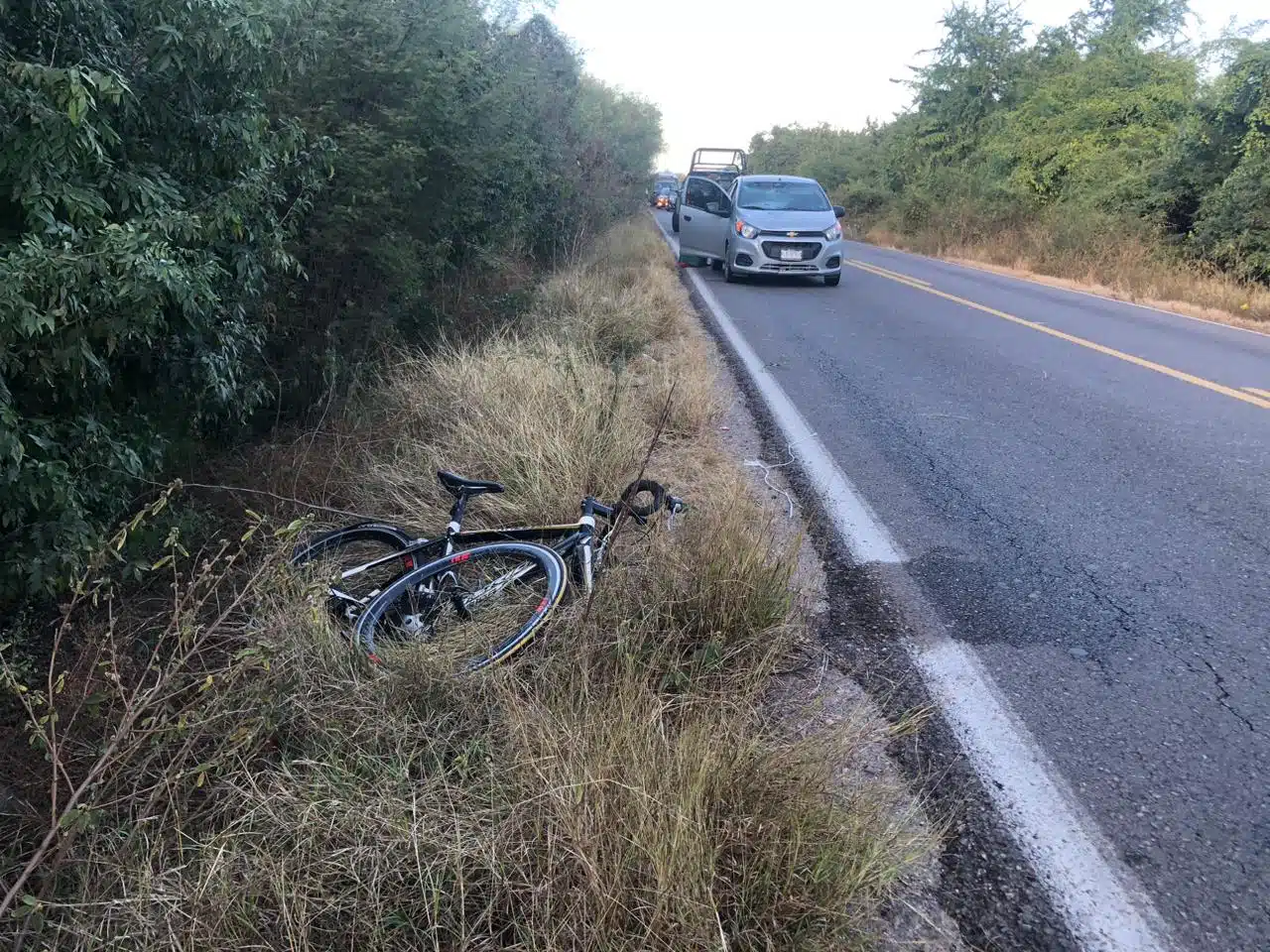 Bicicleta tirada a la orilla de la carretera estatal