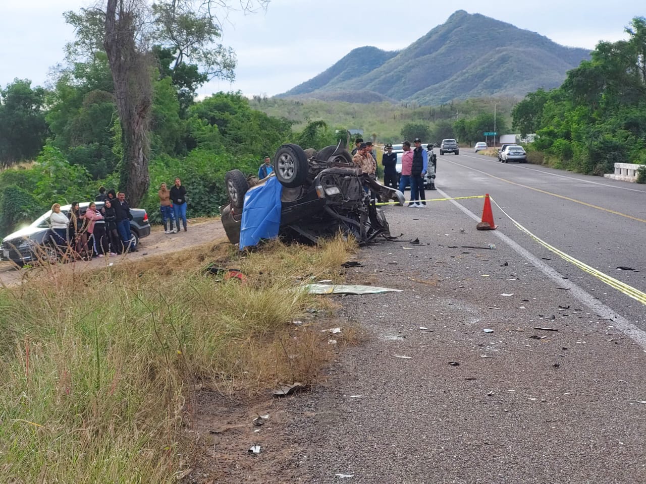 Vehículo volcado a orilla de la carretera y personas observando alrededor