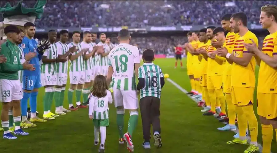 Andrés Guardado junto a sus hijos y jugadores en el campo de futbol en España