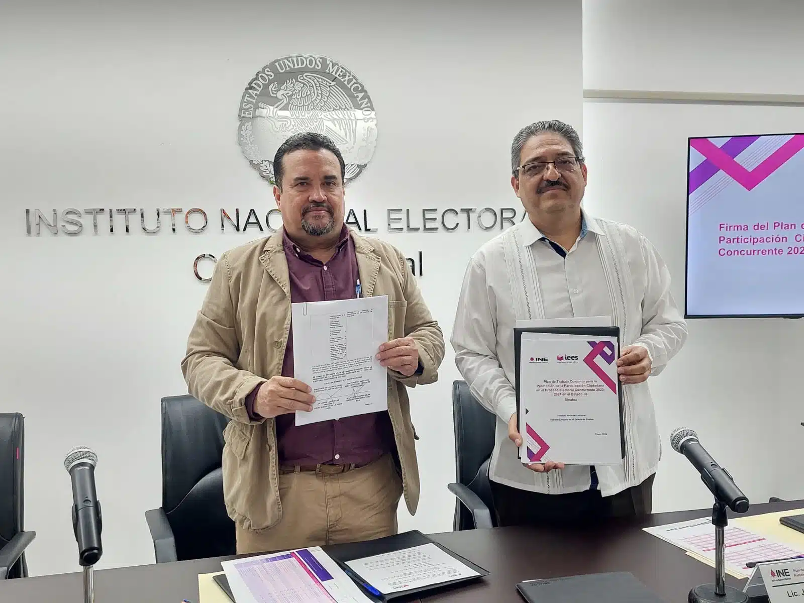 Arturo Fajardo Mejía y Jorge Luis Ruelas Miranda con un documento en la mano cada uno