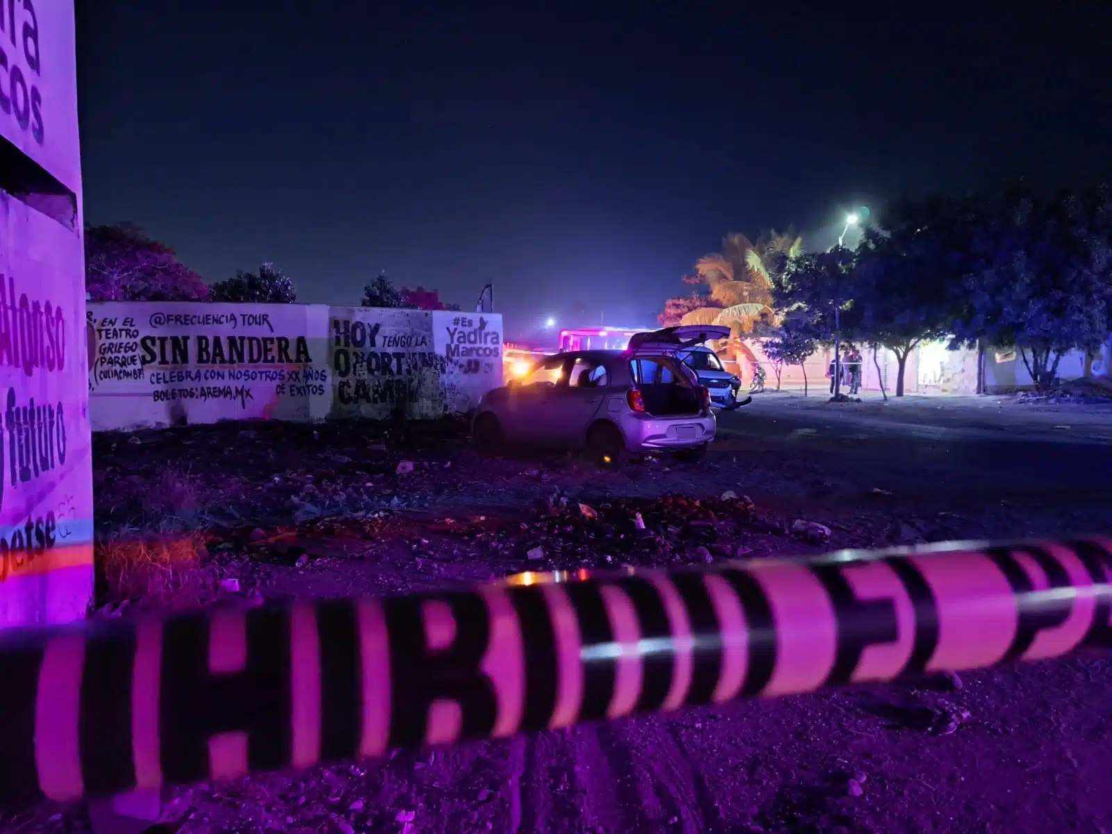 Carro abandonado con impactos de bala y cinta amarilla acordonando el lugar