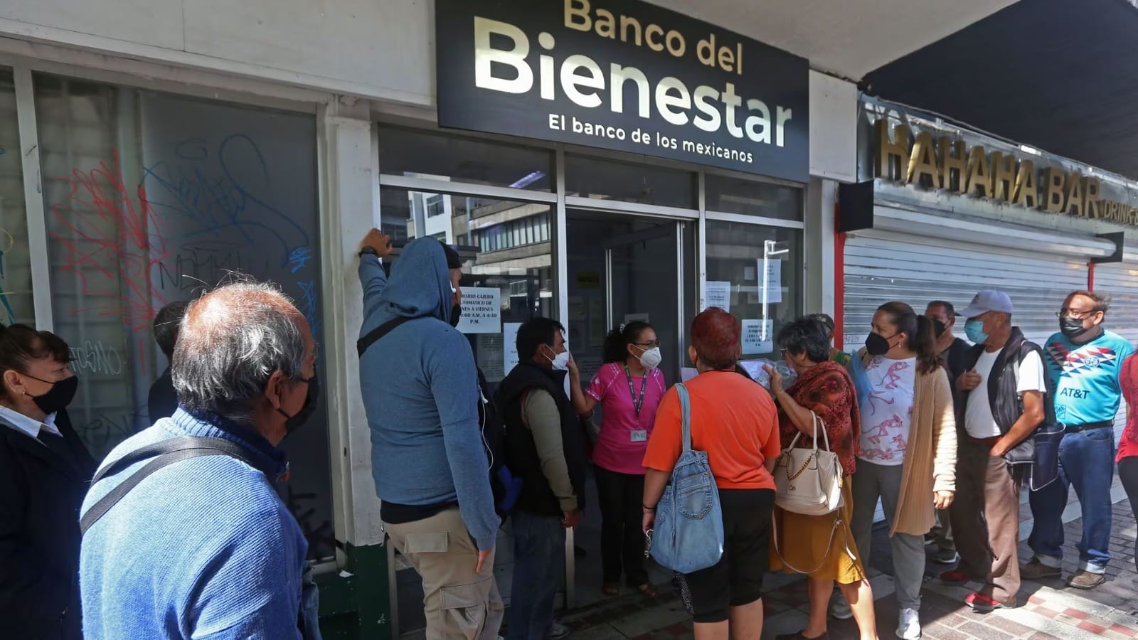 Personas adultas mayores pensionadas a fuera de un banco del Bienestar
