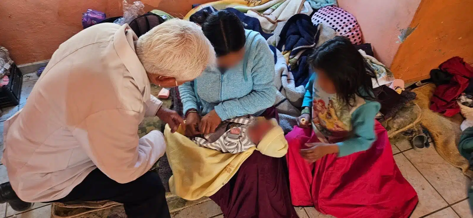 Una persona revisando el ombligo de un bebé en una cuartería de Guasave