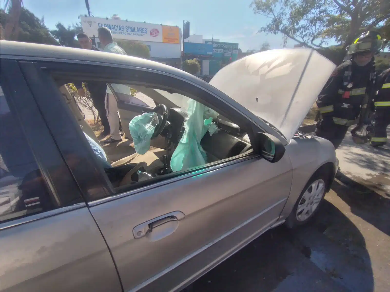 Bombero revisa cofre de un auto tras choque en Mazatlán