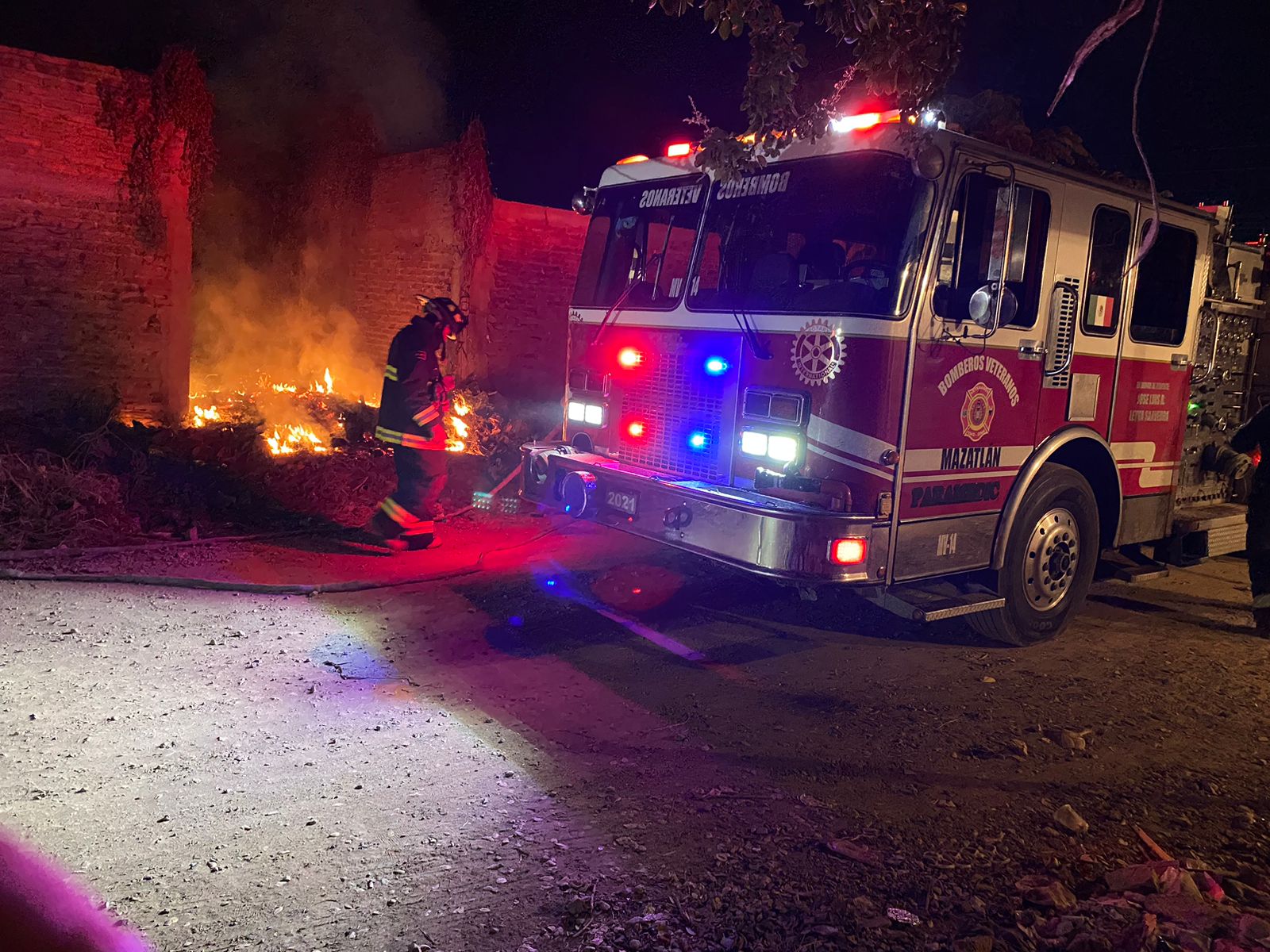 Bomberos en el lugar del incendio afuera de una casa abandonada en la colonia Renato Vega en Mazatlán