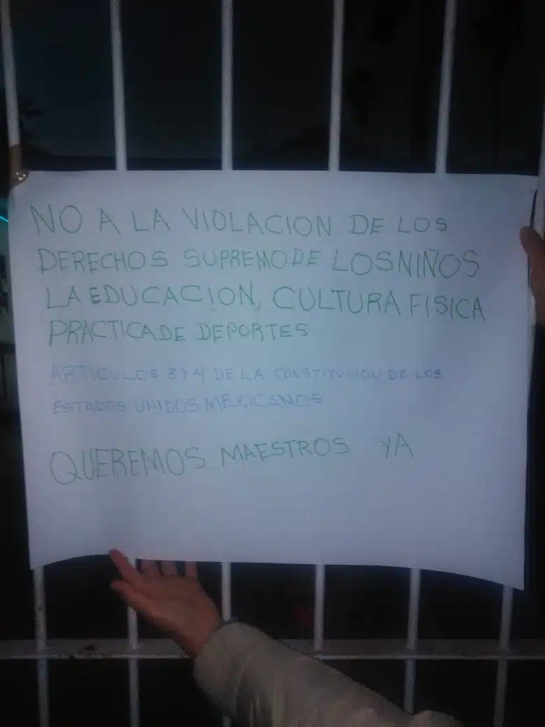 Cartulina pegada en la reja de la Escuela Secundaria Técnica 3 El Carrizo exigiendo solución por falta de maestros