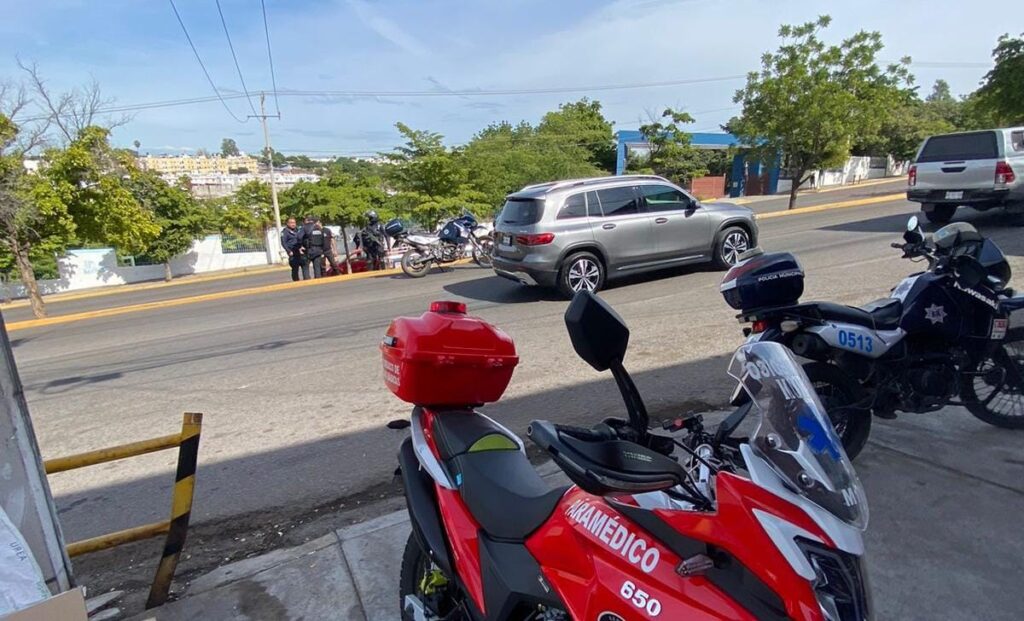 Dos motos sobre una banqueta y en medio de la calle otra moto de la Policía de Culiacán y en medio de la calle un vehículo particular que chocaron