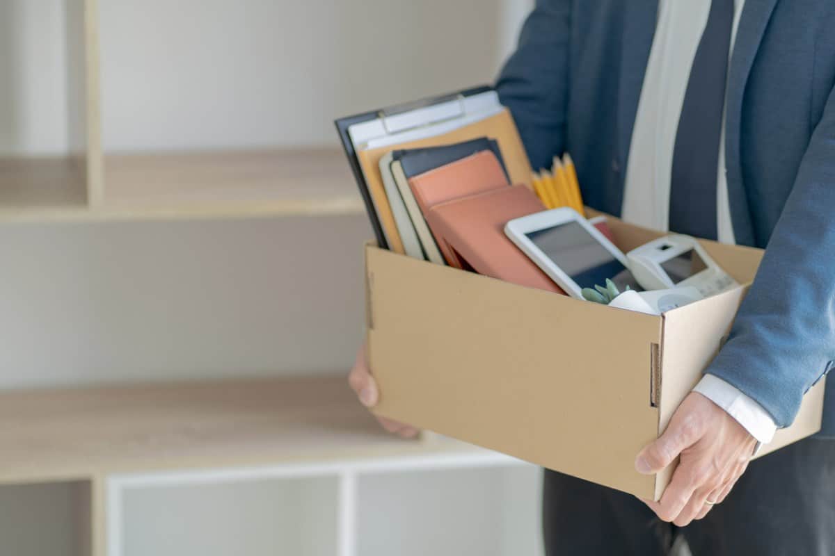 Persona cargando una caja con sus pertenencias tras ser despedido