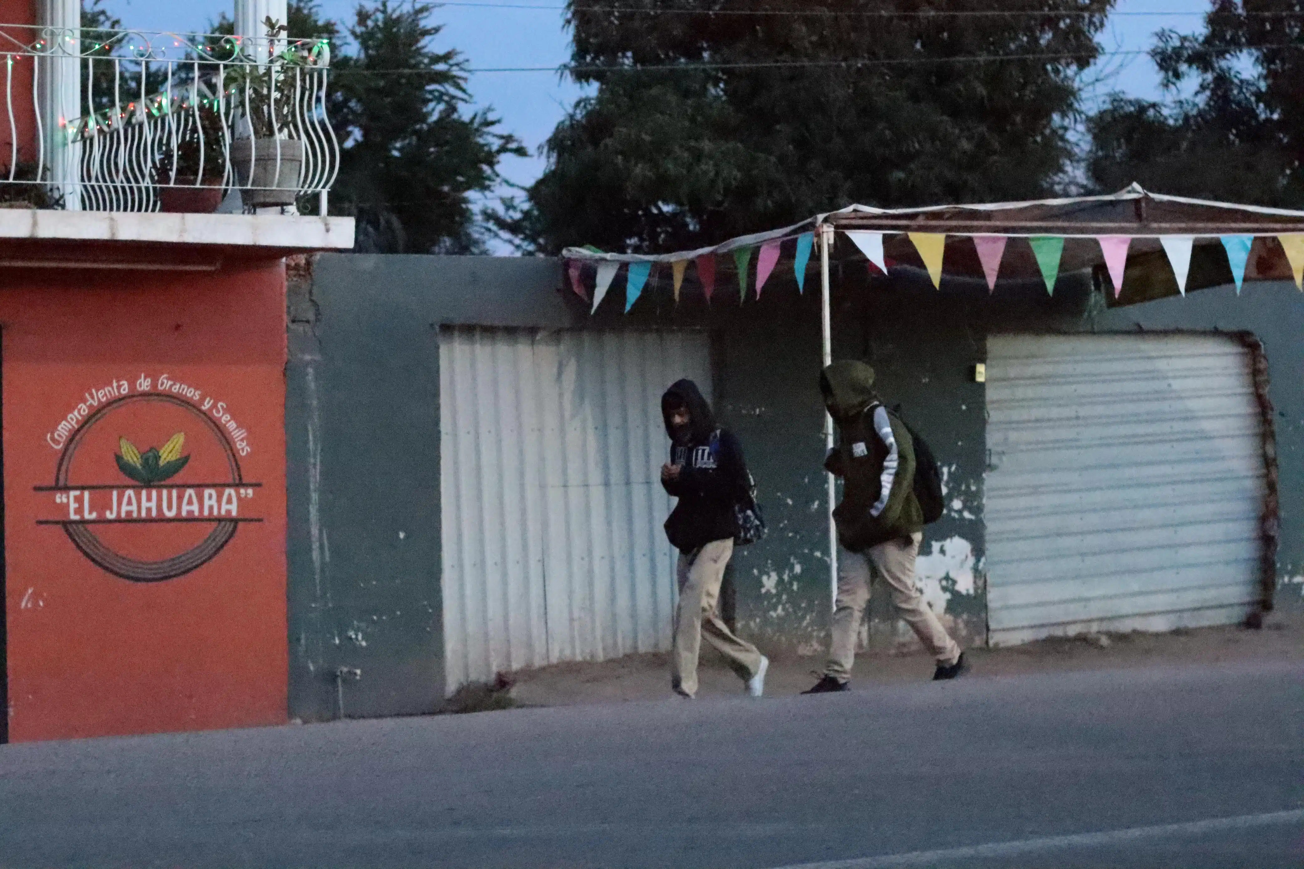 Dos personas caminando abrigados por el intenso frío en Choix