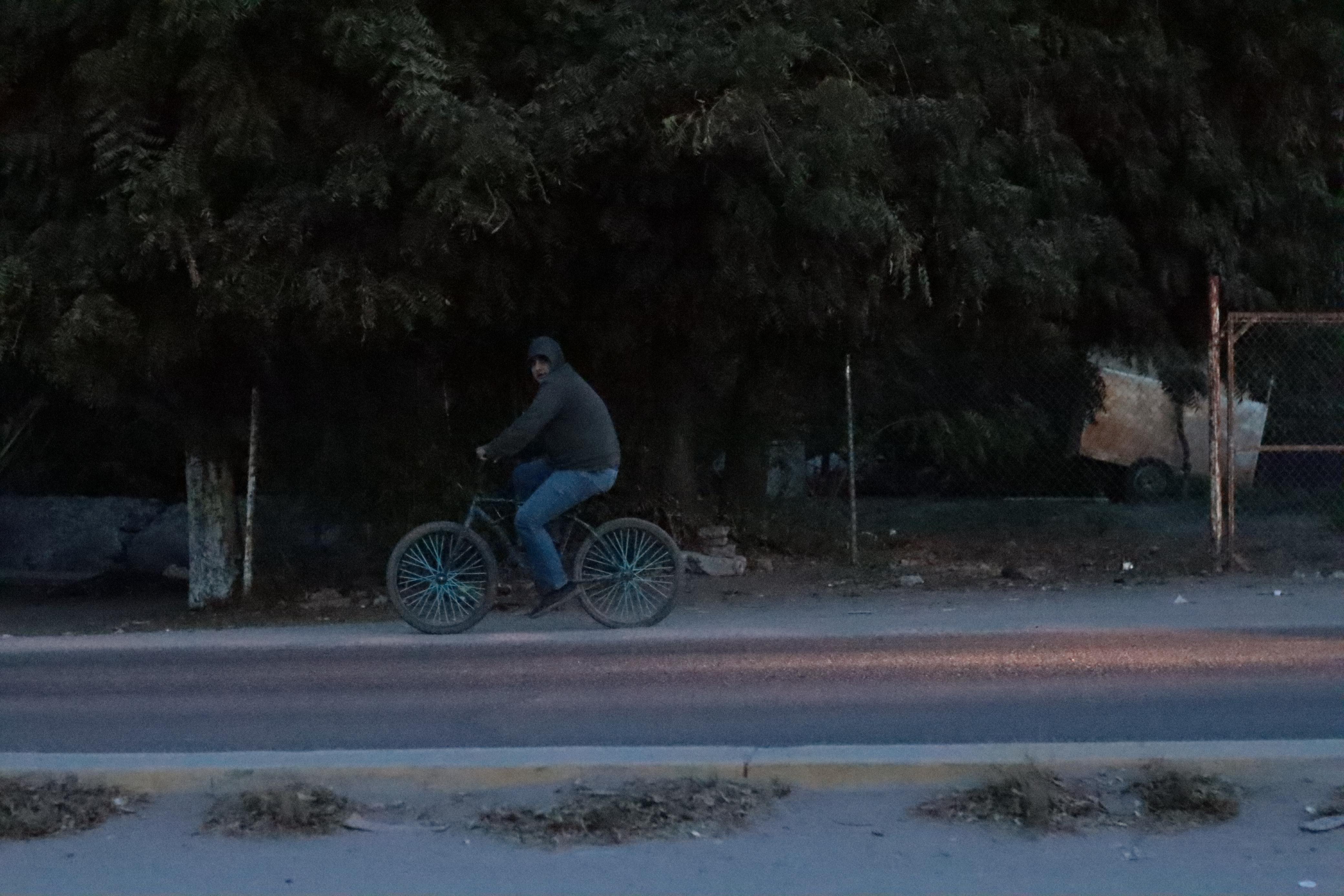 Una persona en bicicleta bien abrigada por el intenso frío en Sinaloa