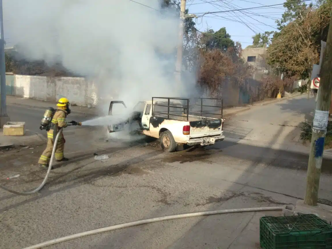 Elemento de bomberos apagando el incendio de una camioneta en Villa Unión