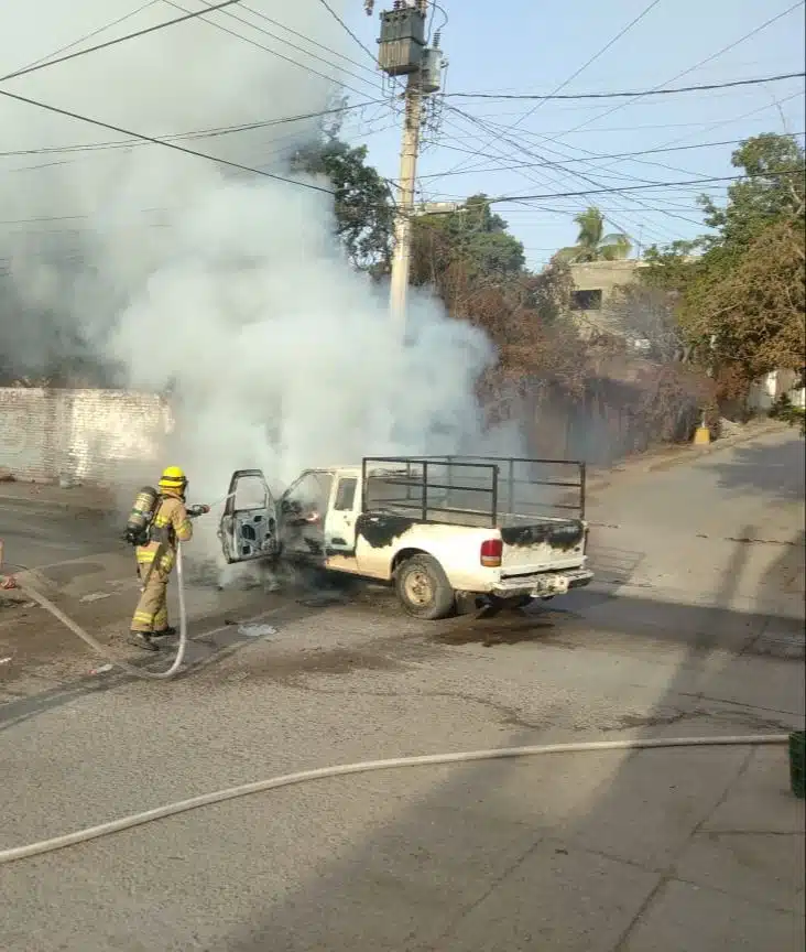 Elemento de bomberos apagando el incendio de una camioneta en Villa Unión