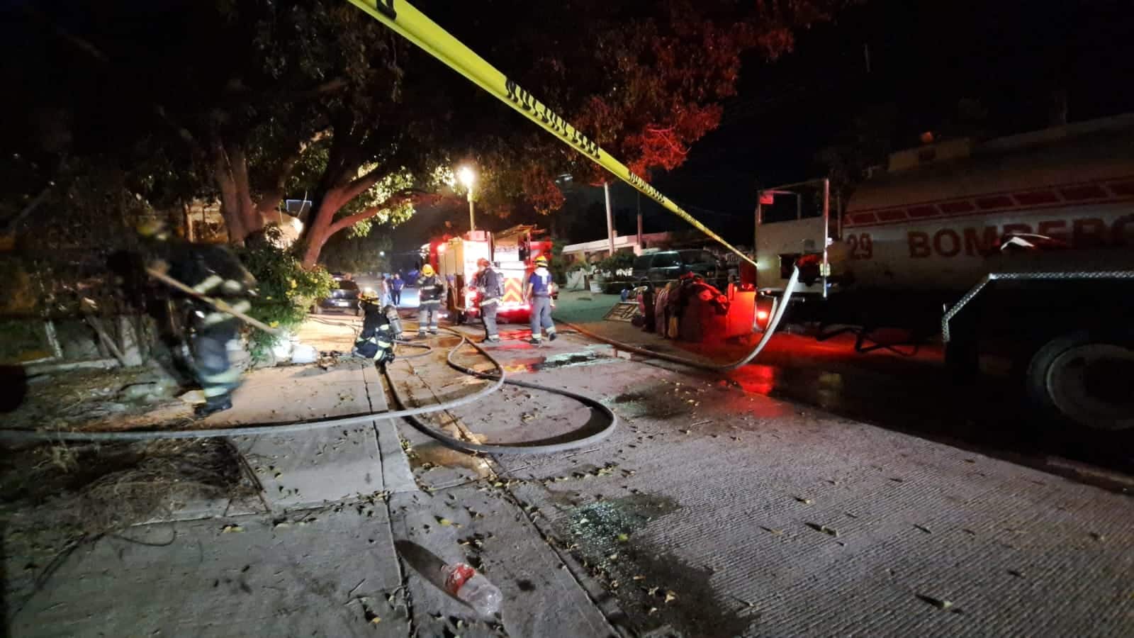 Camión y elementos de bomberos, y una cinta amarilla delimitando el área de un incendio en Culiacán