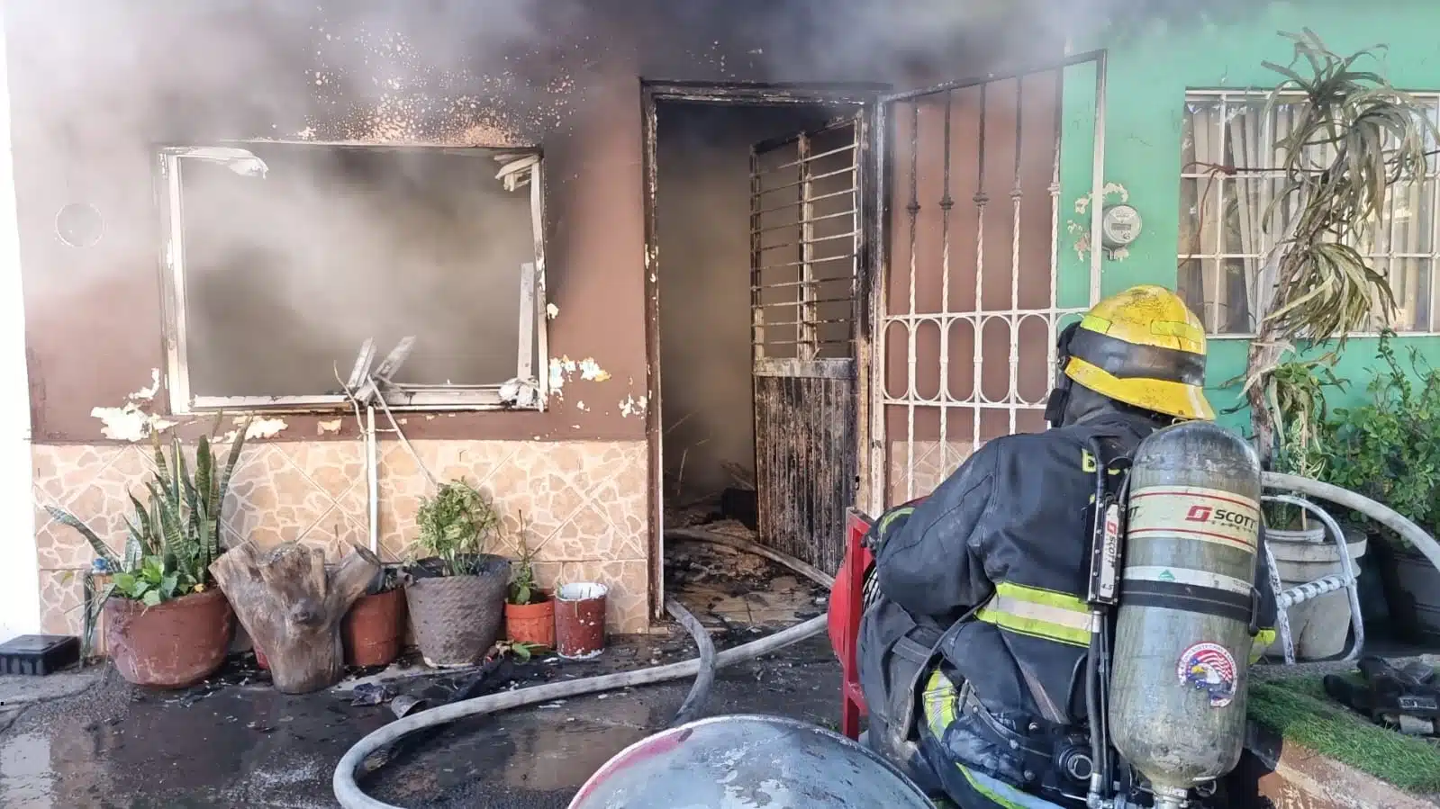 Elemento de bomberos en un incendio de una casa en Culiacán