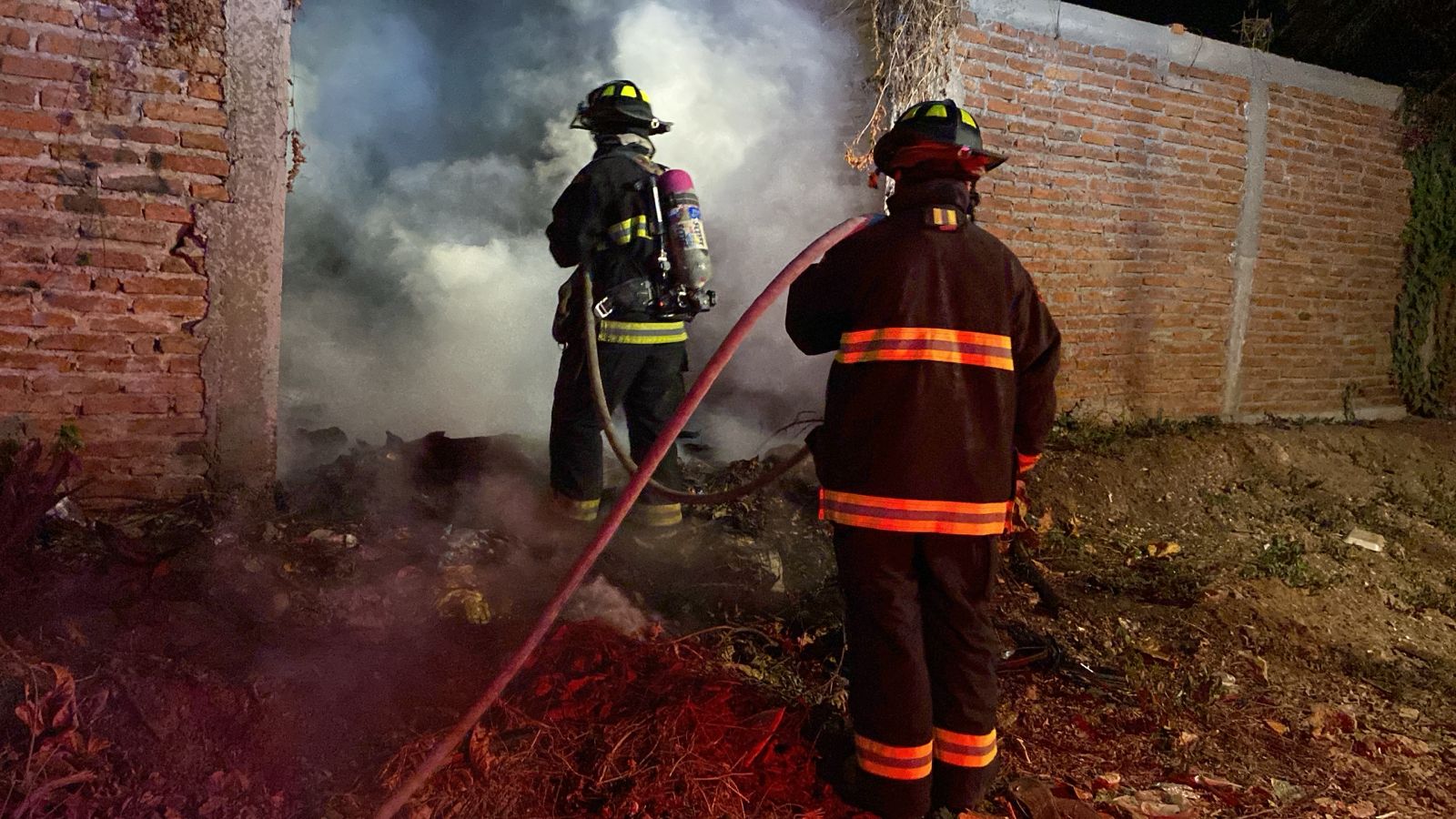 Bomberos en el lugar del incendio afuera de una casa abandonada en la colonia Renato Vega en Mazatlán