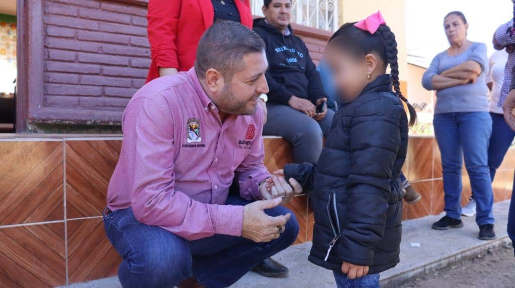 José Paz López Elenes con una niña de la comunidad La Soledad, Badiraguato