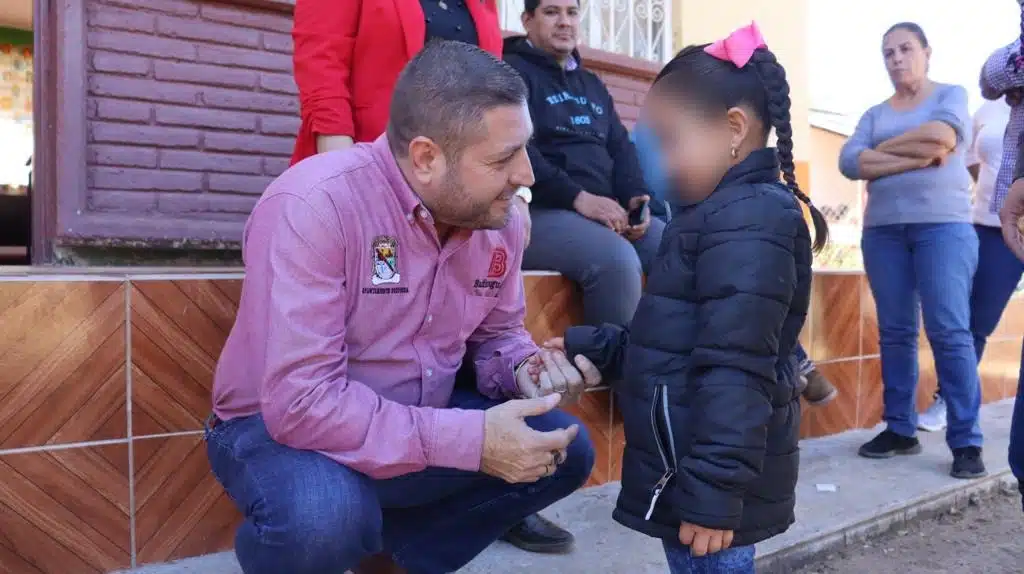 José Paz López Elenes con una niña de la comunidad La Soledad, Badiraguato