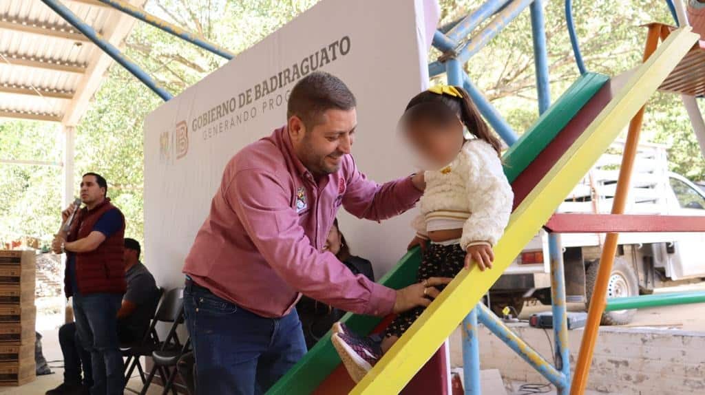 José Paz López Elenes con una niña de la comunidad La Soledad, Badiraguato, en una resbaladilla