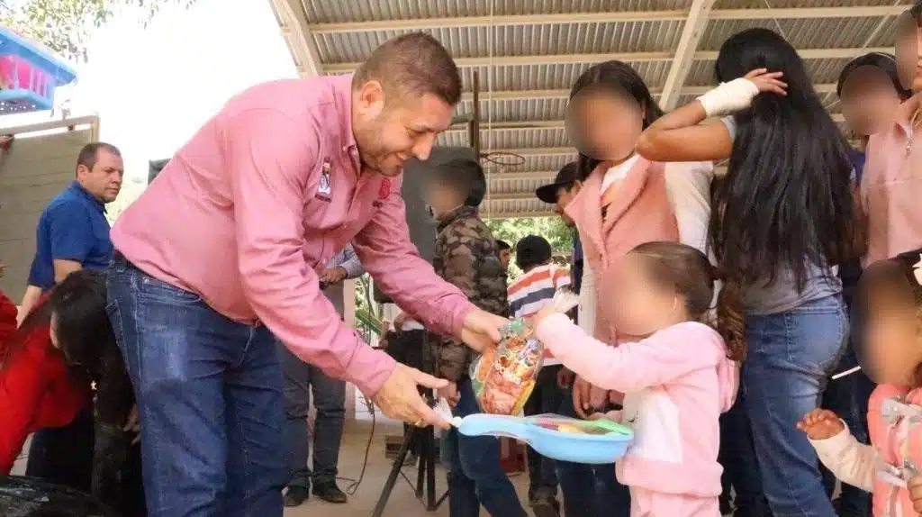 José Paz López Elenes dando apoyos alimenticios a niños de la comunidad La Soledad, Badiraguato