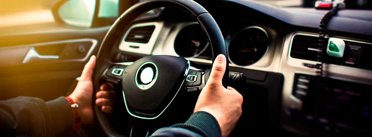 Unas manos tomando el volante de un carro