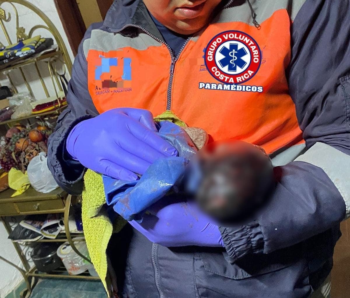 Las manos de un paramédico Voluntario de la comunidad de Costa Rica, Culiacán, cargando a un bebé recién nacido