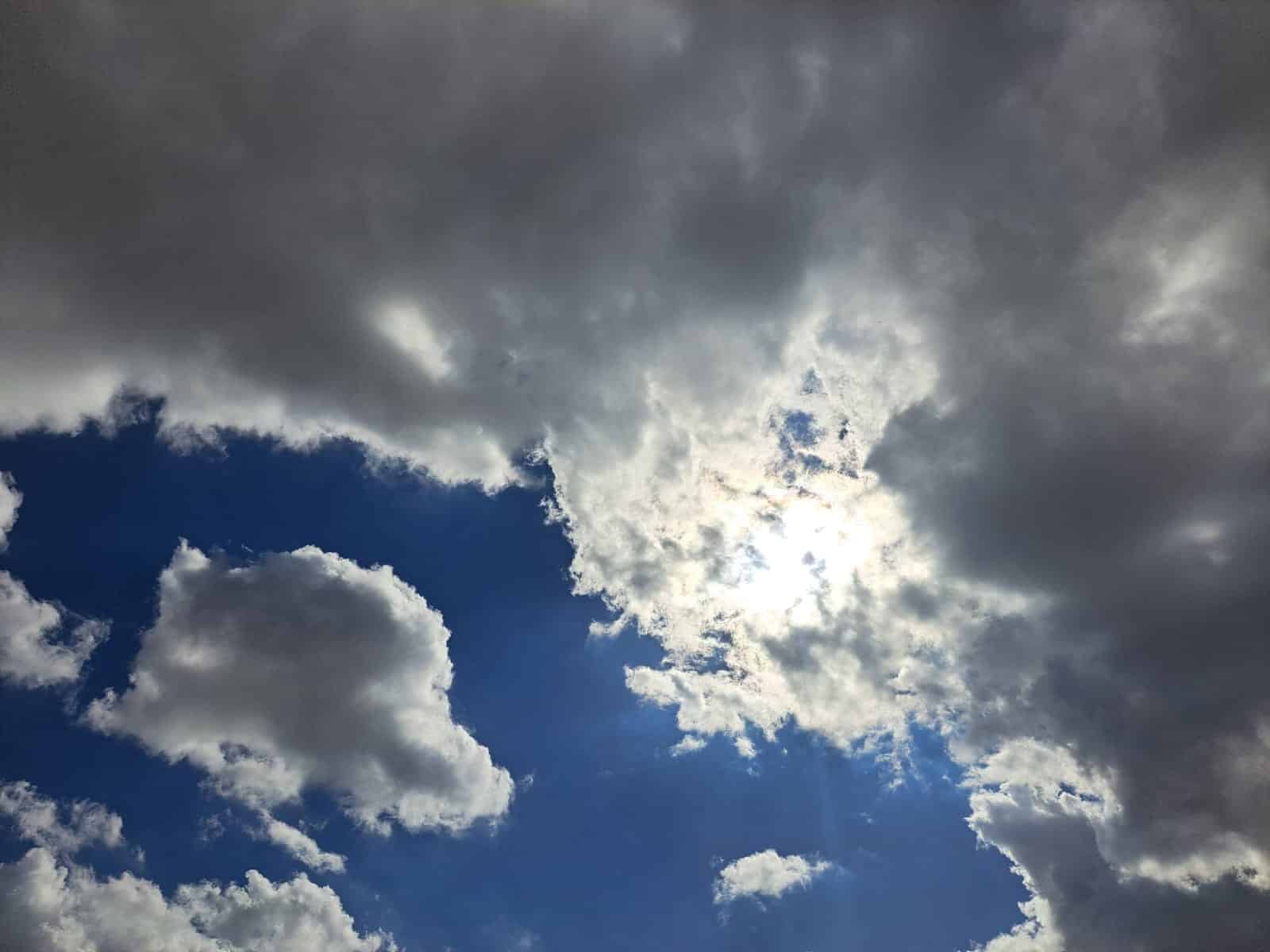 Nubes grises y una blanca donde se oculta el sol