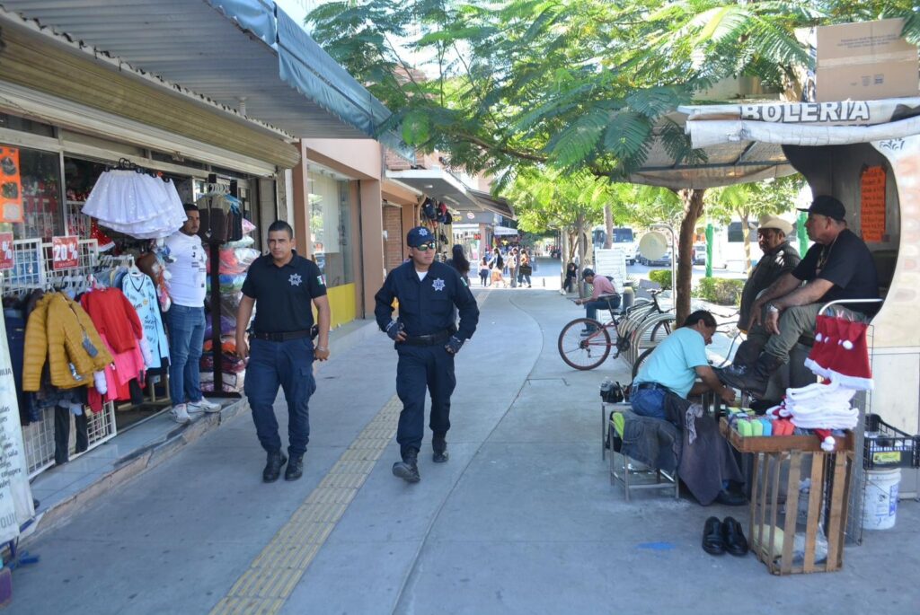 2 elementos de la Policía Municipal de Ahome caminando por la calles