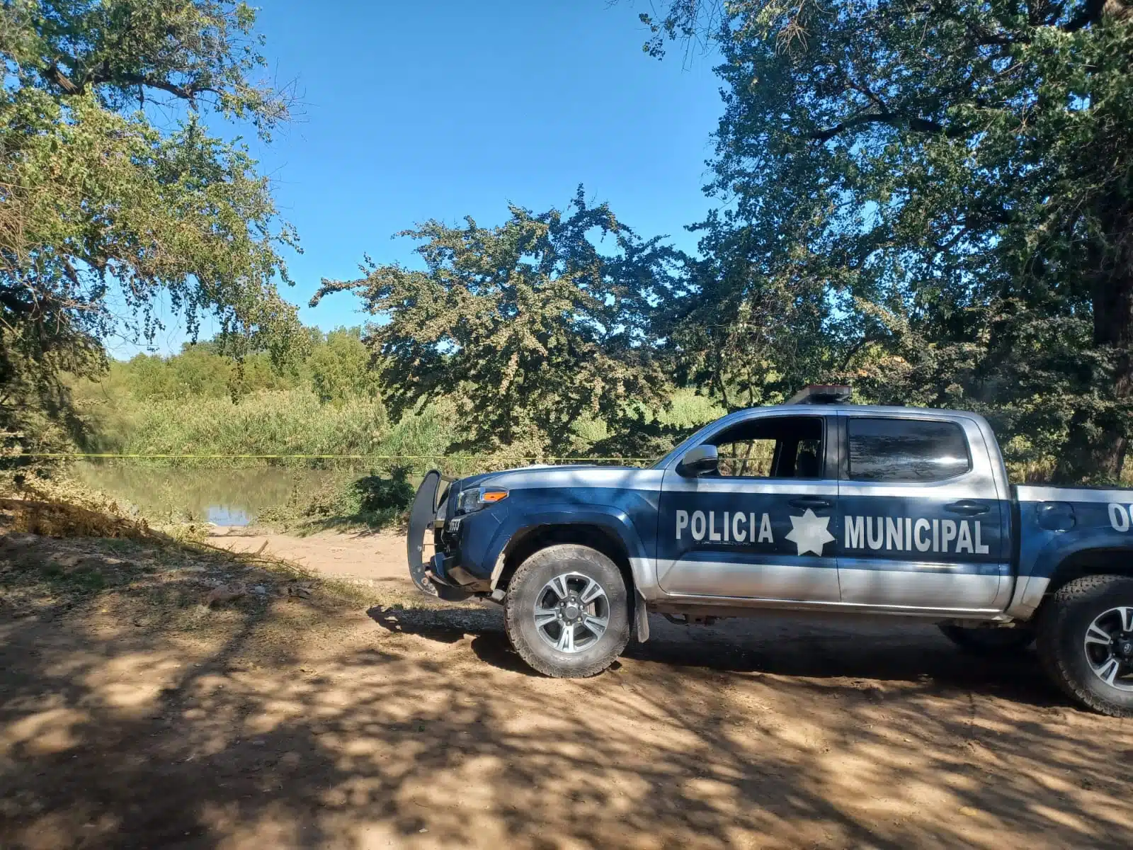Camioneta de la Policía Municipal de Guasave en el lugar donde encontraron a un hombre sin vida en el río Sinaloa