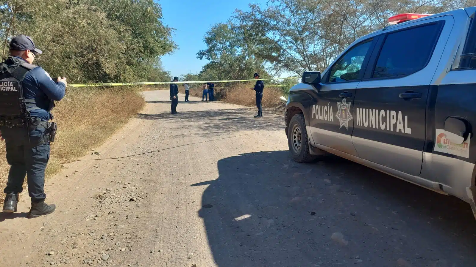 Patrulla y elementos de la Policía Municipal de Culiacán y cinta amarilla delimitando el área donde encontraron a don Eliazar sin vida