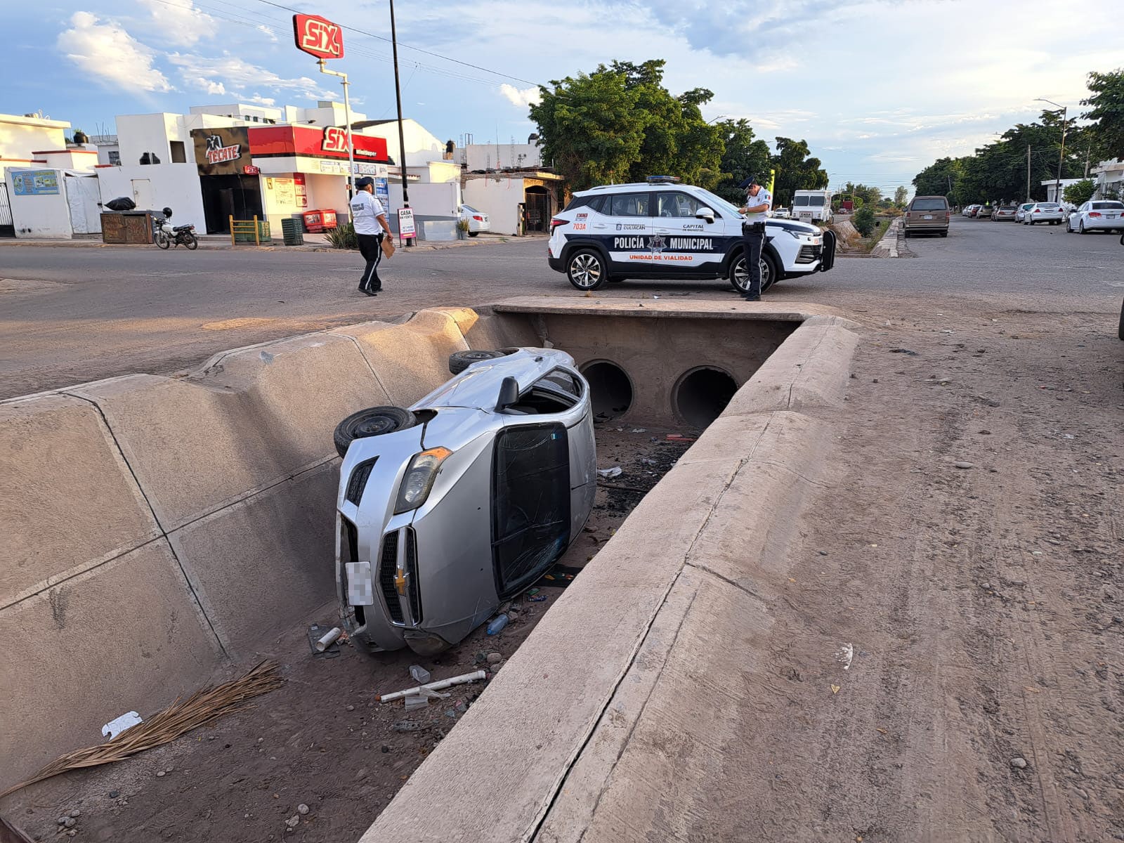 Vehículo adentro de un canal tras accidente a donde arriban policías de Tránsito de Culiacán