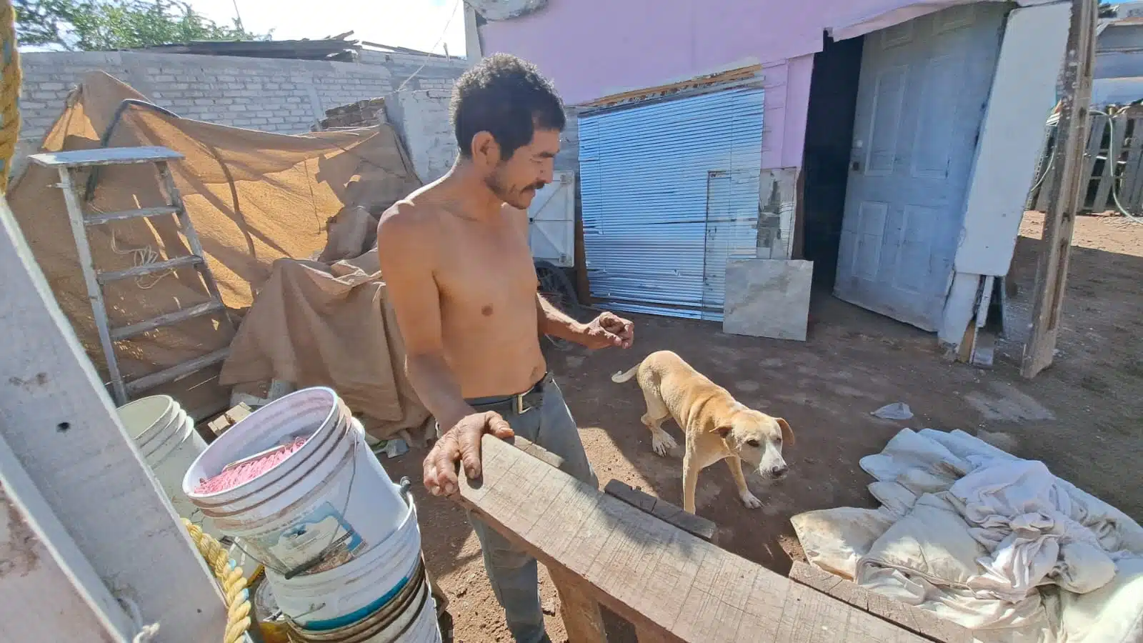 Vicente Briseño Cota sin playera en pleno frío junto a su perrito en Los Mochis
