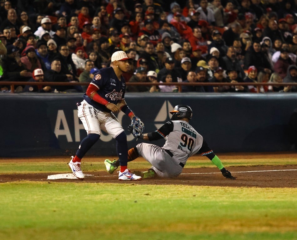 El tercera base de los Águilas, Yangervis Solarte, busca poner out al dominicano Andretty Cordero de los Naranjeros