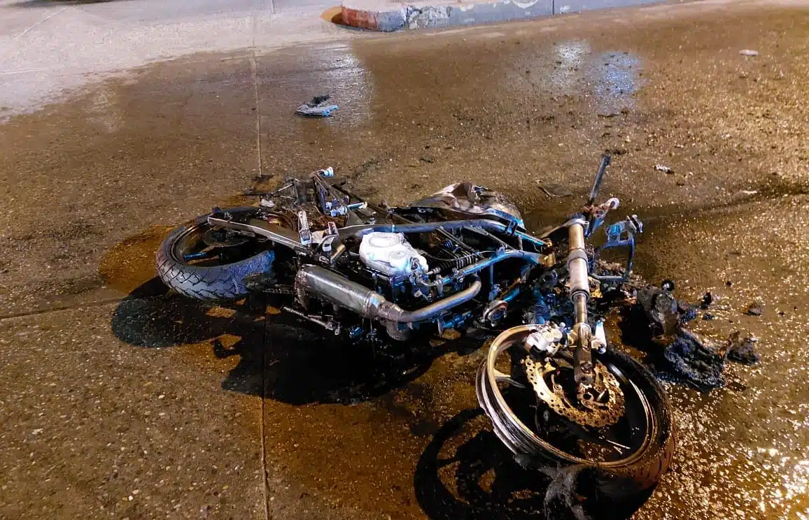La motocicleta en la que viajaban los jóvenes se incendió tras el accidente.
