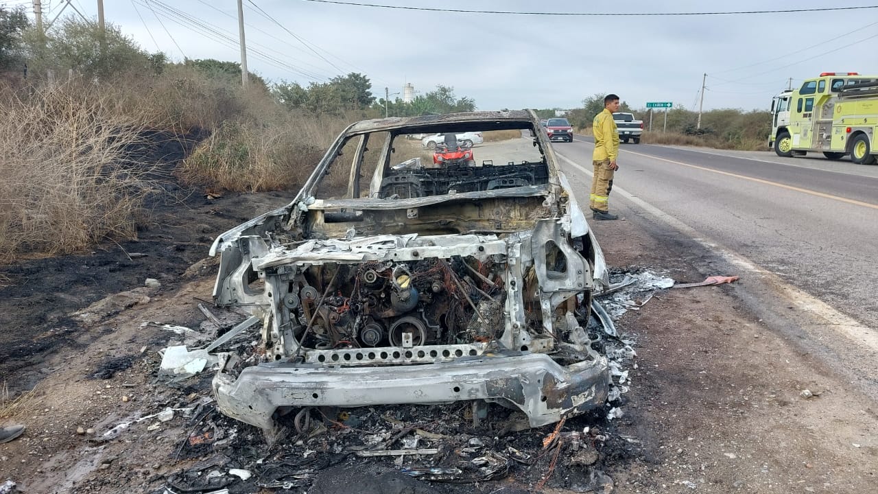 Bomberos atendiendo el incendio de la camioneta