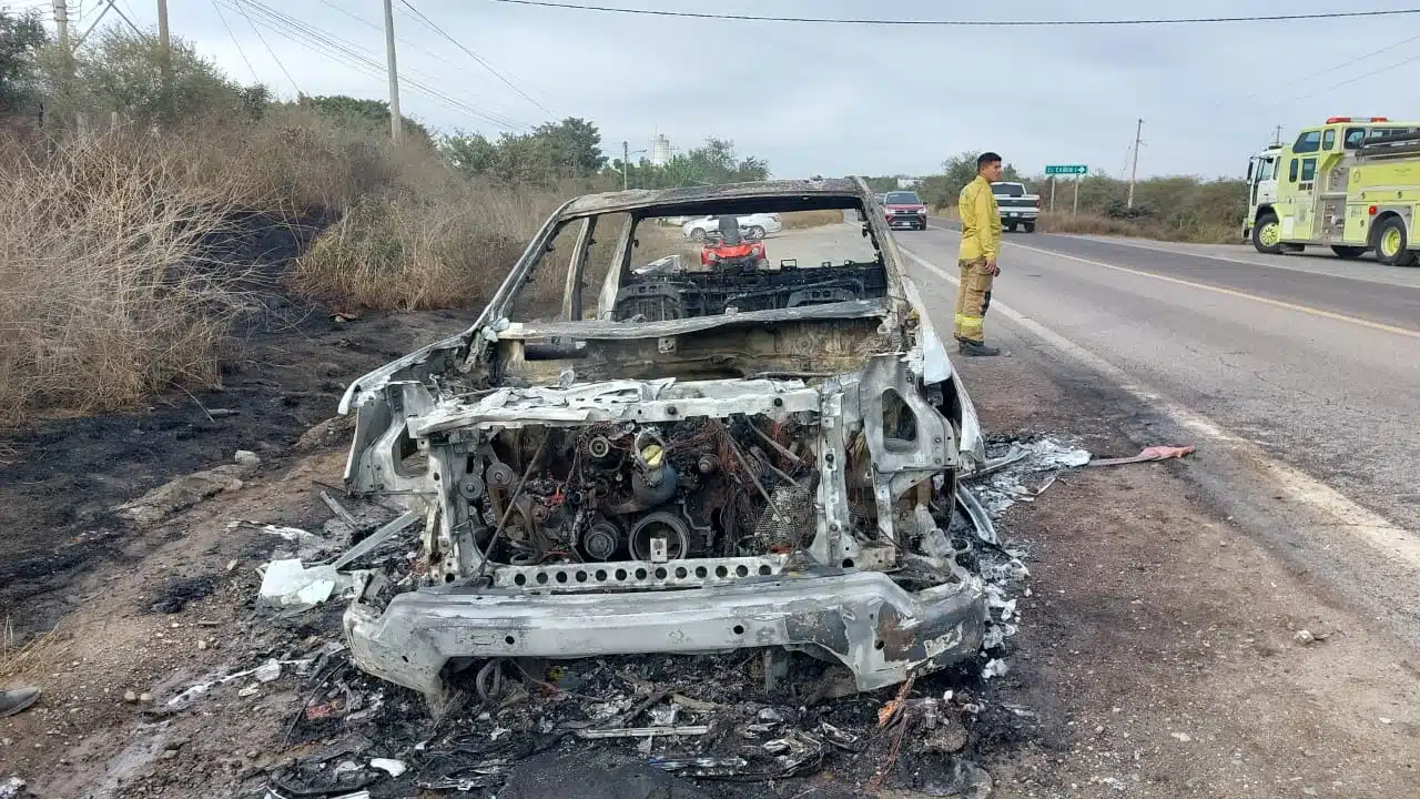 Bomberos atendiendo el incendio de la camioneta