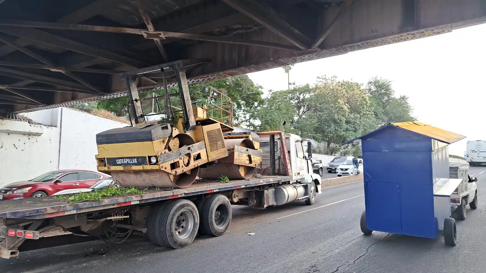 Tráiler cargado con máquina aplanadora se atora en el Puente Negro de Culiacán