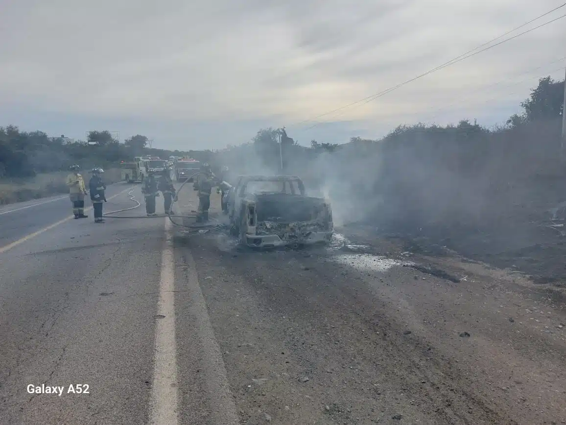 Bomberos atendiendo el incendio de la camioneta